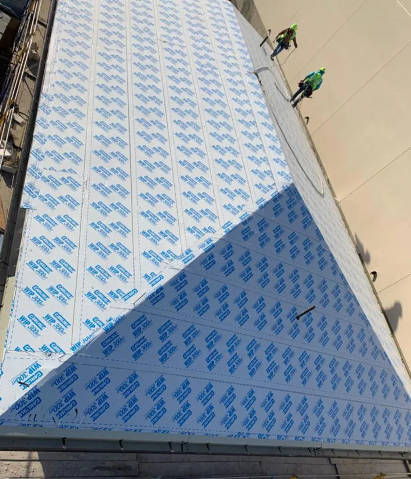 Professional roofers installing underlayment on a metal roof in Santa Paula